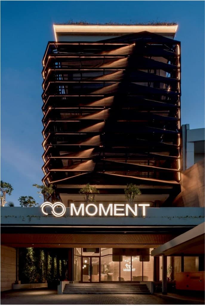 The MOMENT headquarters, Surabaya — a hand-woven screen by BYOLiving wraps the upper floors.